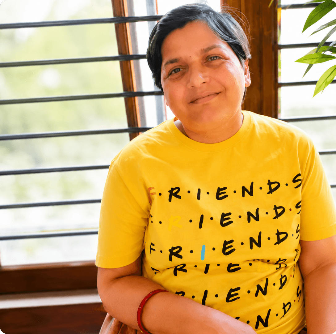 Mukta smiling in a yellow Friends t-shirt