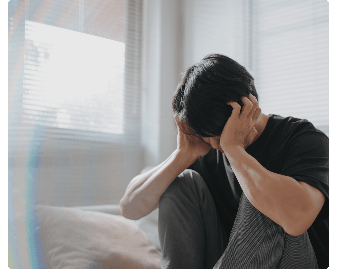 Person sitting with their head in their hands