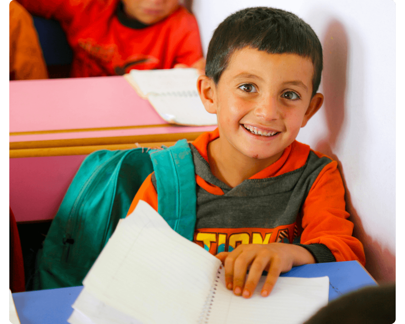 Young boy smiling in a classroom