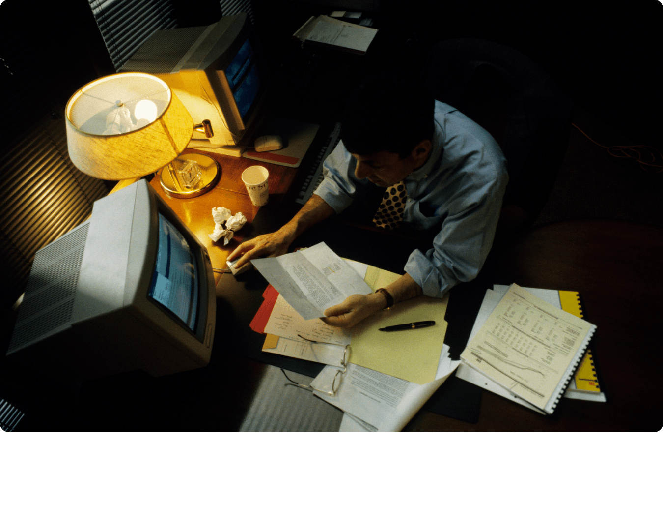 Person working at a desk under a lamp